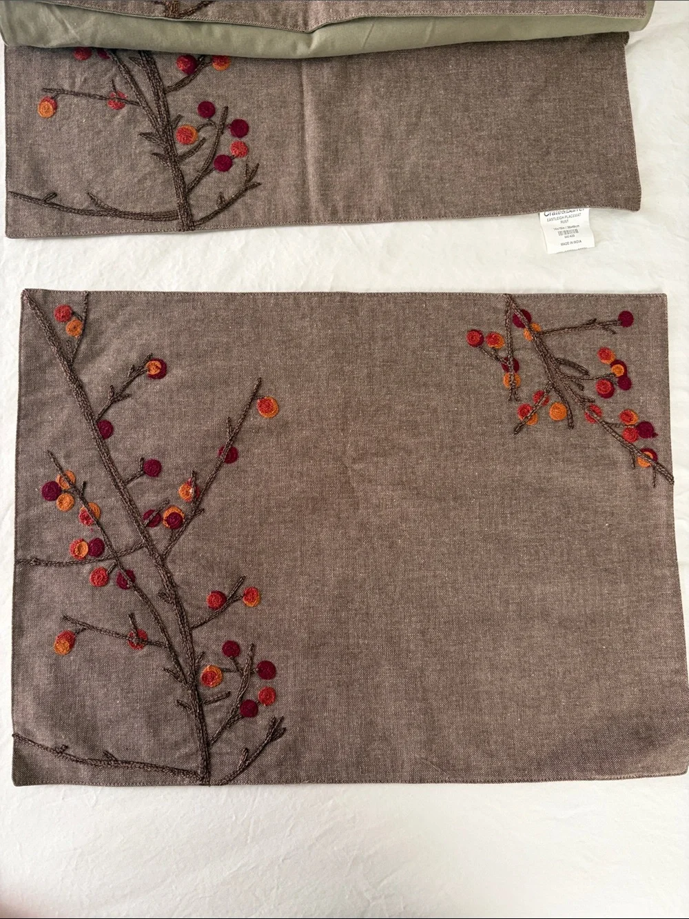 Crate&Barrel Embroidered Placemats with Shades of oranges and reds.